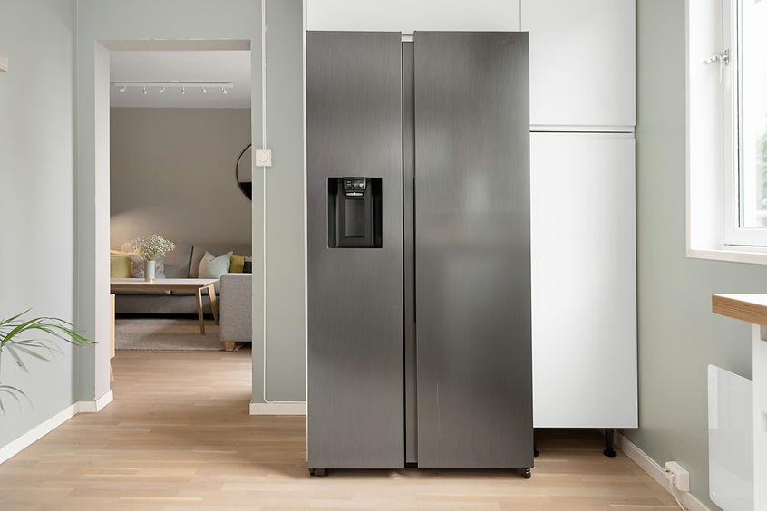 A sleek, stainless steel fridge with a water dispenser stands in a modern kitchen