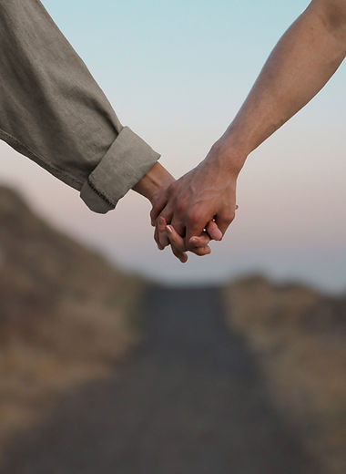 Couple holding hands outdoors, representing connection and emotionally focused therapy (EFT) for couples and individuals in California