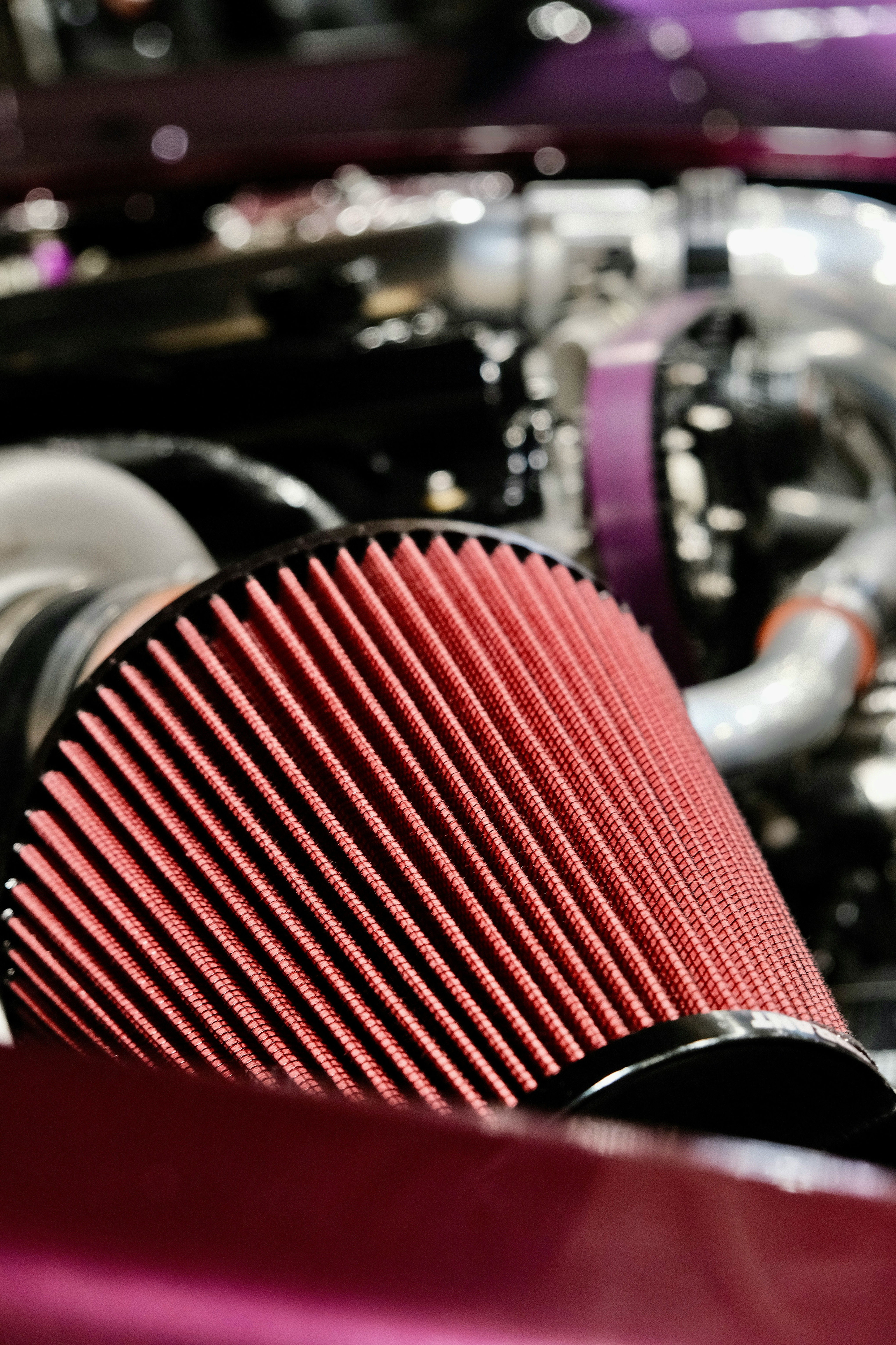 Red conical air filter in car engine