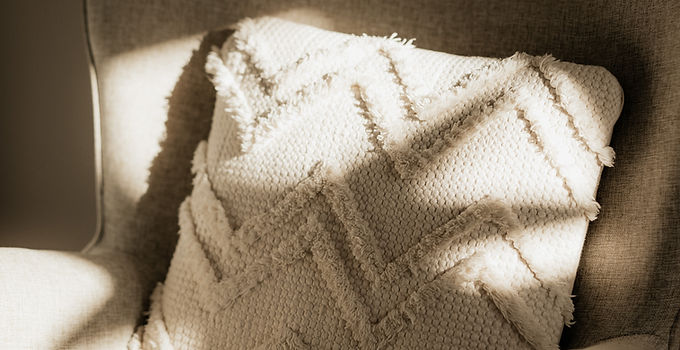 Zig-zag patterned pillow on a cream coloured arm chair