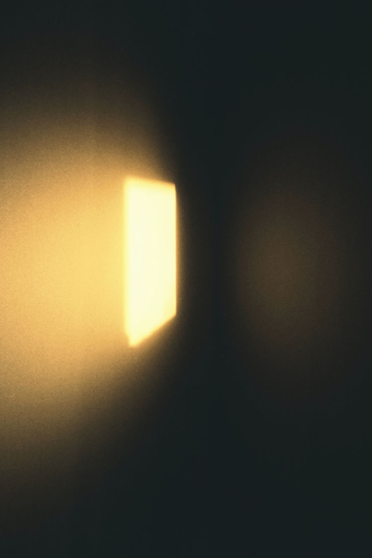 An open poetry journal resting in soft warm morning sunlight.