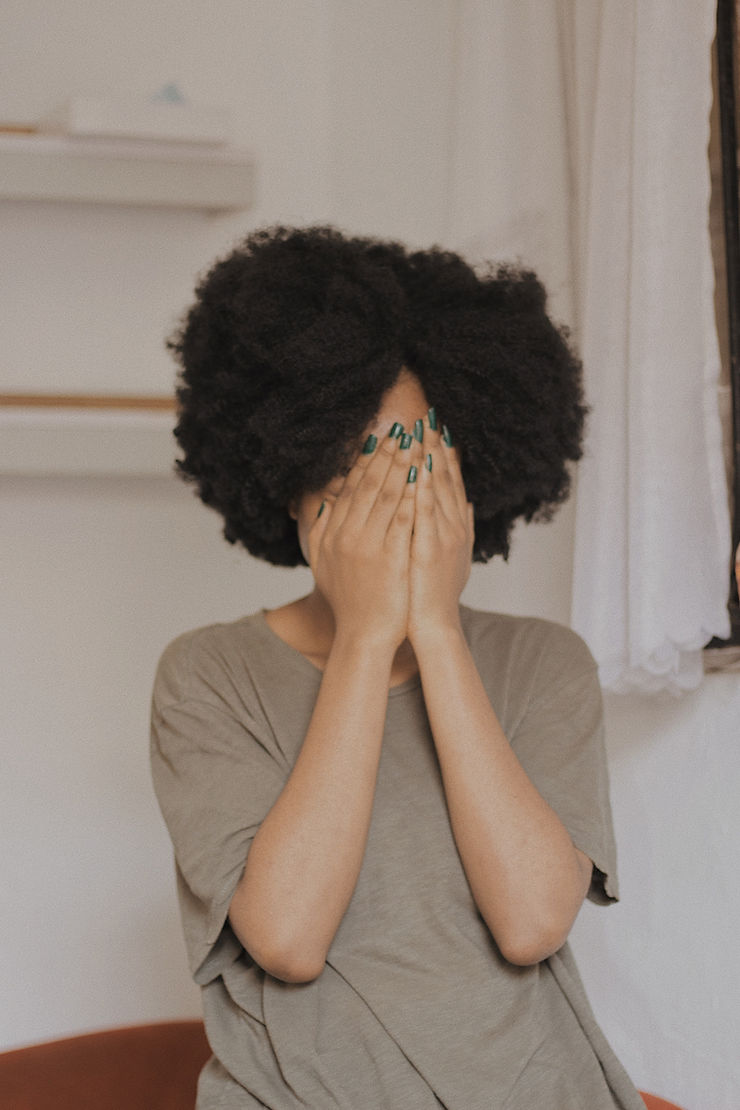 shy black girl covering her face with her hands