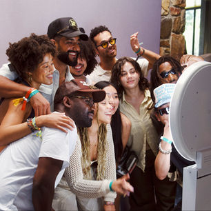 Group of friends gathered around a modern photo booth smiling and posing at a Portland event – Pixel Booth party rental