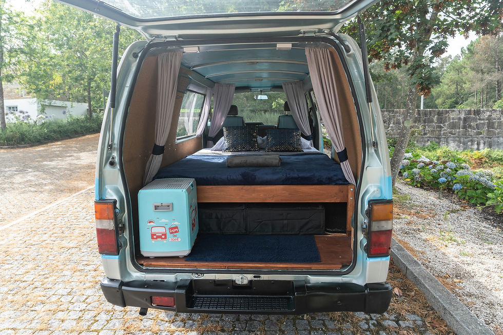 Rear open view of a light blue motorsport race van showing custom wooden furniture units and storage layouts