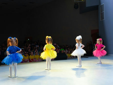 A happy little girls dancing and singing freely on a stage, full of joy and confidence for My Poetry Corner.