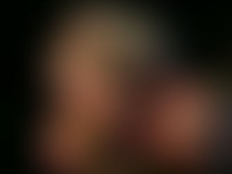 Pink and white roses in full bloom with some wilted petals, set against a dark, blurred background, evoking a somber yet beautiful mood.