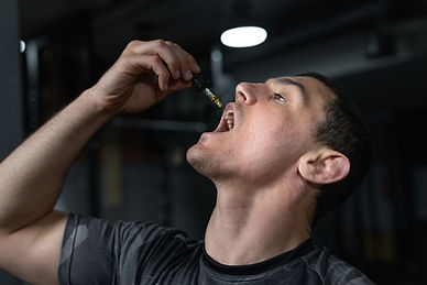 person dropping a liquid supplement into his mouth