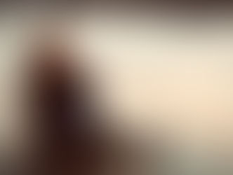 Woman sitting by a lake at sunset, lost in thought, symbolising a pause to notice what's on autopilot