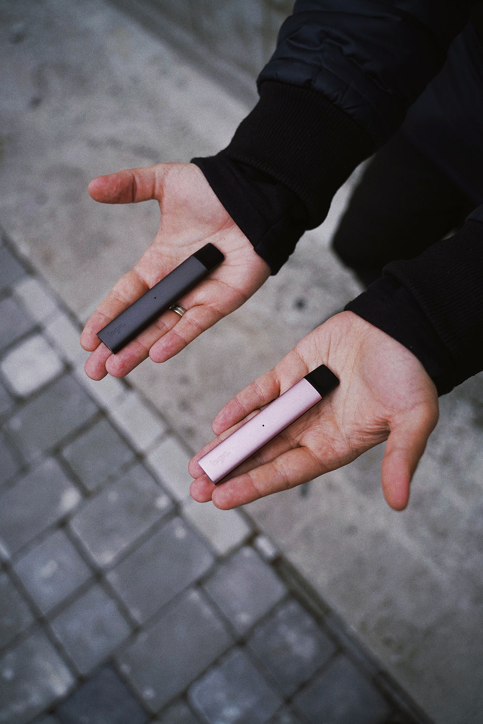 two hands deciding what is the better vape pen?