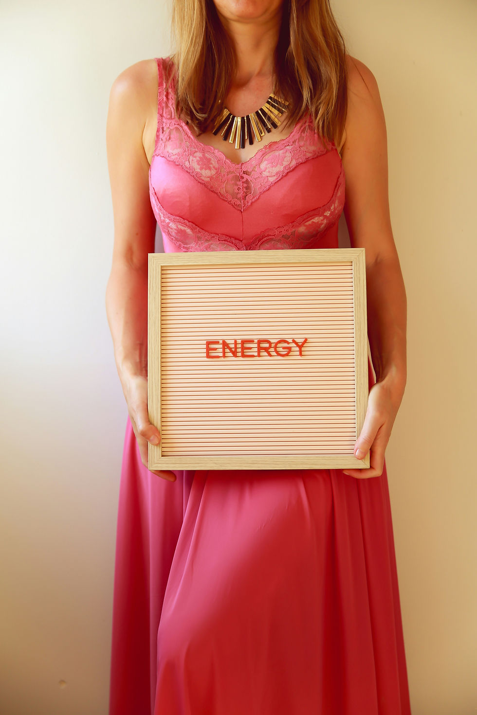 woman holding notebook with words "to do" on page, holding pencil over notebook, on top of table
