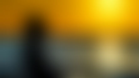 Silhouette of a person gazing at a vibrant orange sunset over the ocean, creating a serene and reflective mood.