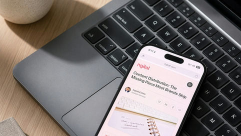 An iphone sitting on a laptop with a web browser opened to a page on content distribution strategy