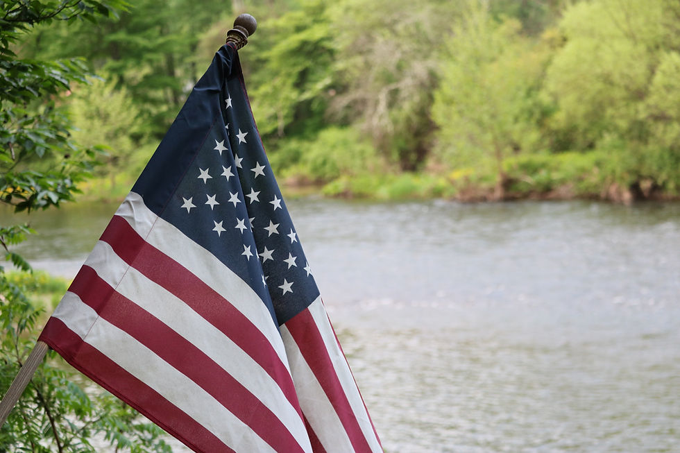 American flag outdoors by a river, symbolizing clarity and strength in Trump’s Big Beautiful Bill.
