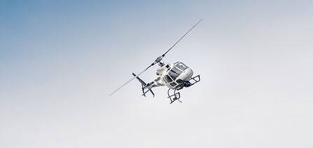 Helicopter doing a manuever in against a blue sky