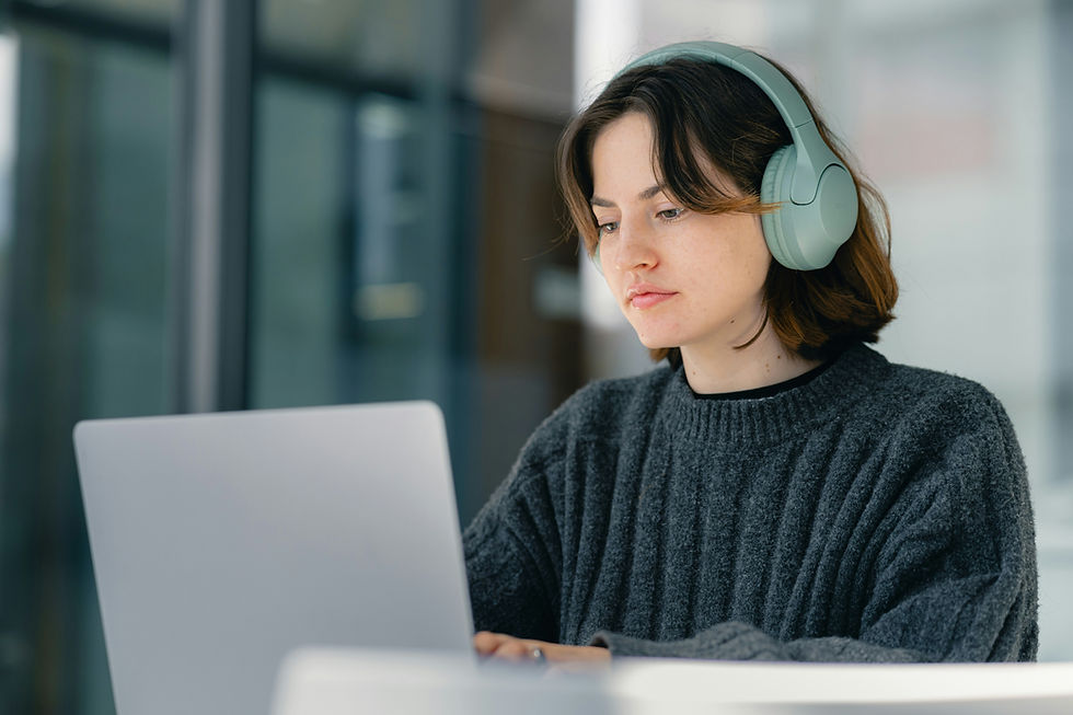 a student wearing headphones working on here laptop
