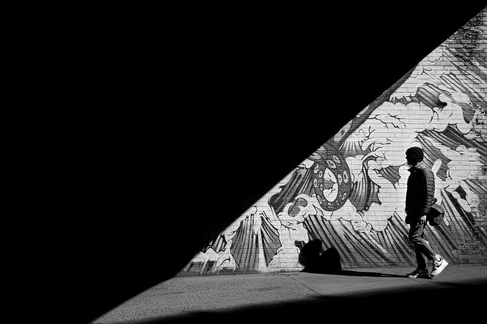 Man walking infront of a mural