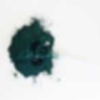 Top View spilt Spirulina Powder against white background 