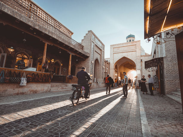 Vicolo storico di Bukhara con persone e portici tradizionali in Uzbekistan
