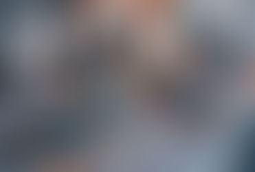 Festive table with checkered cloth, plates with napkins, candles, and pinecones. Warm cozy ambiance with green and blue accents.