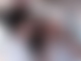 Two women in white shirts smile and gesture with peace signs in a bright, restaurant setting. Hanging lights create a cheerful atmosphere.