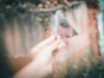 Person looking at their reflection through a mirror, partially obscured, representing self-awareness and confusion in relationships.