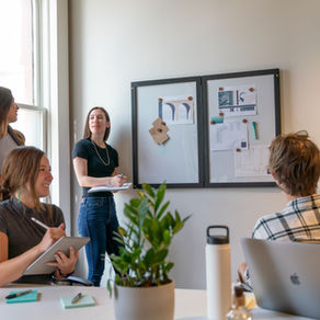 Pic of 5 young founders having a meeting in their new office space.