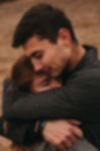 A man hugs a woman that has joined The Wellbeing & Recovery Collective.