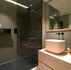 salle de bain avec douche, support de douche, miroir, vasque et divers rangement pour illustrer l'organisation d'une salle de bain