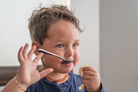 toddler with a spoon in his mouth