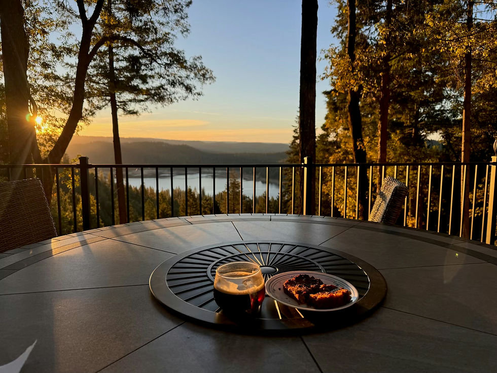 A steaming cup of Rwandan coffee placed on a table outside with scenic mountain views in the background