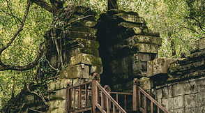 Moss-covered ruins and a wooden walkway at Beng Mealea temple
