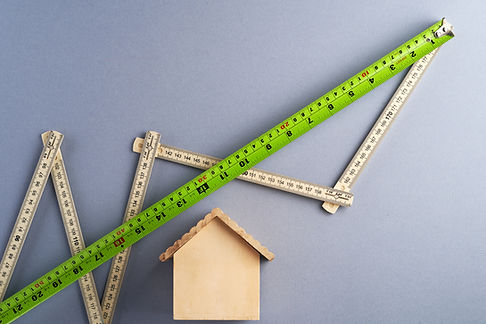 A wooden house with measuring tape above. Image by eskay lim