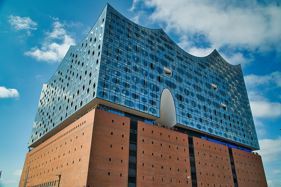 Elbphilharmonie in Hamburg by Herzog & de Meuron: curved glass panes above a brick warehouse, each reflecting a different part of the sky