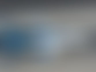 Aerial view of an Alaska Airlines jet on a runway. White and blue aircraft with a shadow cast on the tarmac. Clear sky above.