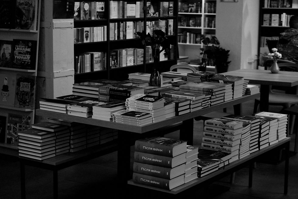 Wide-angle view of printed novels stacked beside a paper world map.
