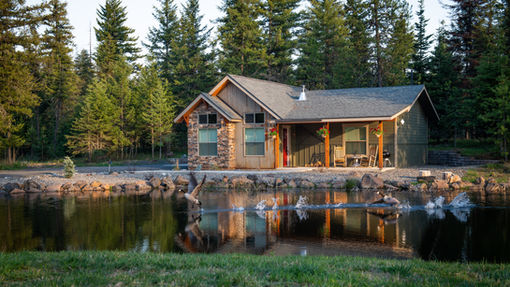 Short-term rental cabin in forest setting illustrating short-term rental tax tips for Airbnb owners, surrounded by pine trees and secluded vacation rental views.