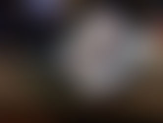 An open tan first aid kit with rolled bandages, medical supplies, and sealed items on a wooden table. The scene conveys preparedness.