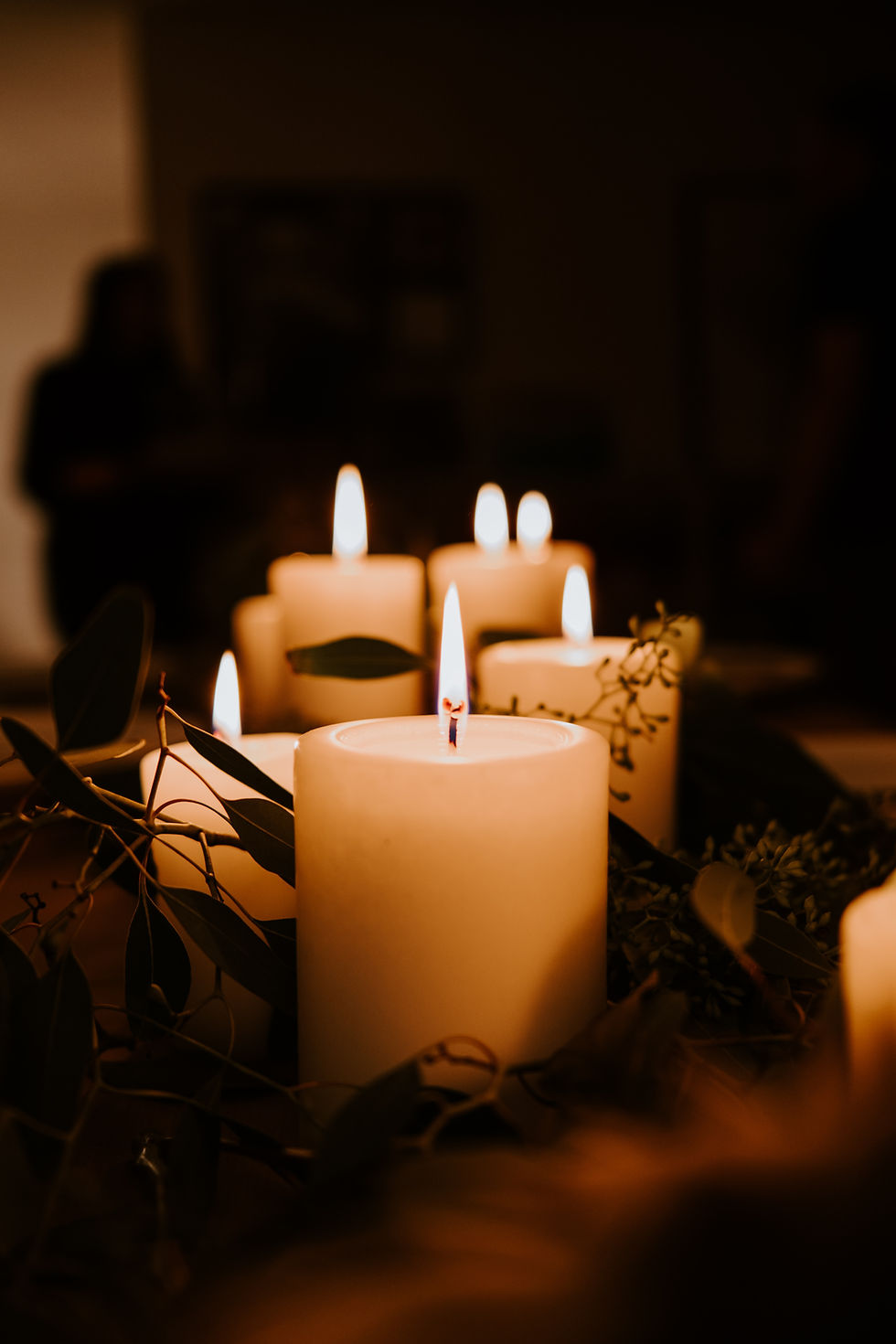 Lit candles in the darkness with some foliage