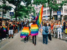 protesters carrying lgbt flag