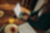 Person typing on a laptop at a wooden table with breakfast