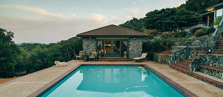 Backyard swimming pool beside a stone cabana