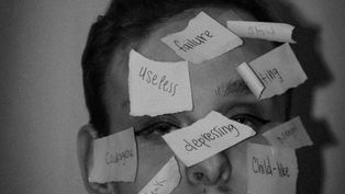 Man's face labeled with negative words