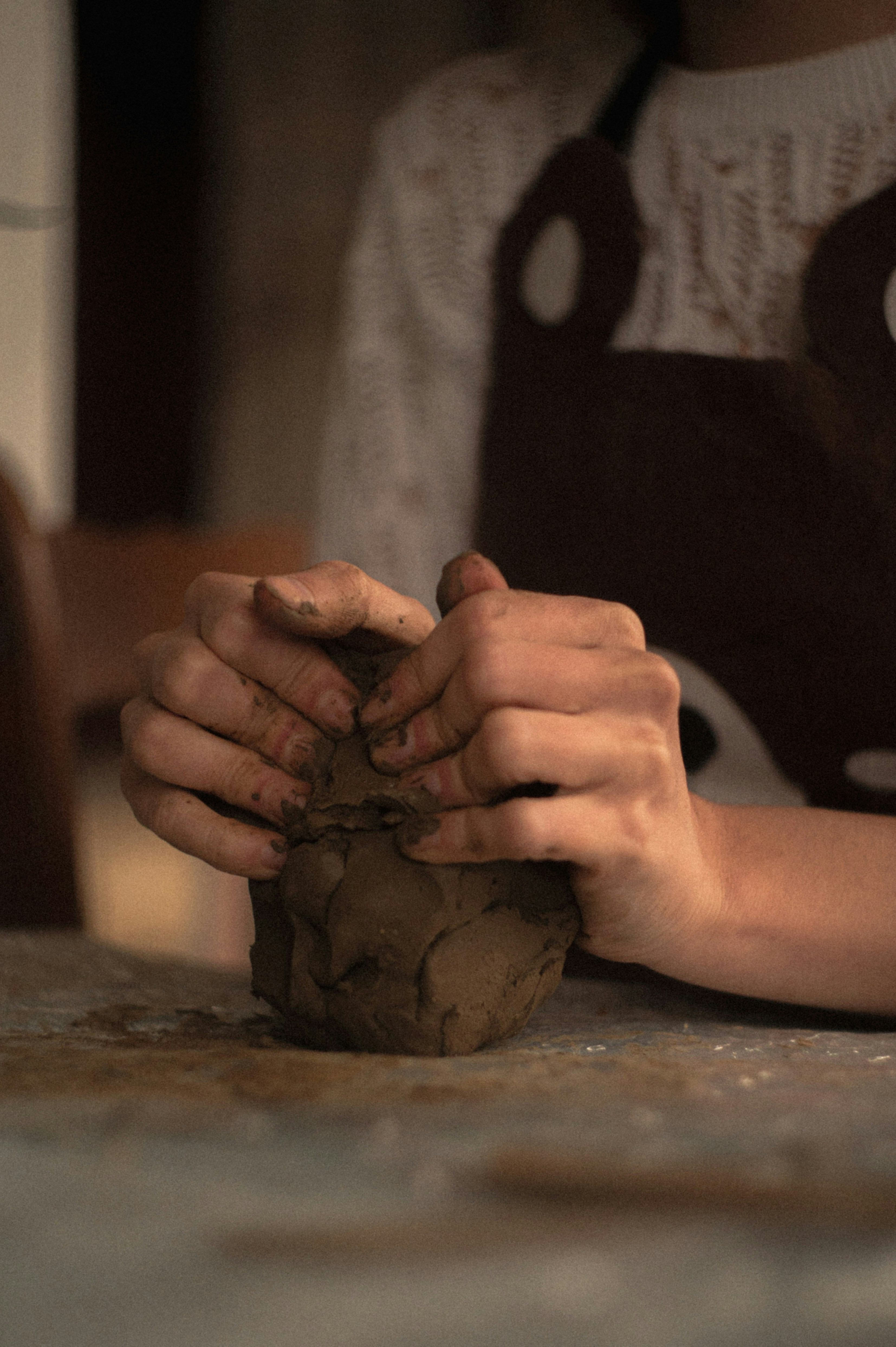 Hands shaping a piece of clay, representing how personal identity continues to evolve and take shape over time.