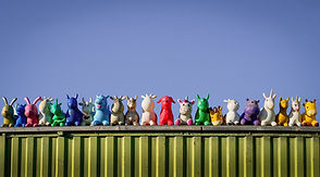 A variety of different animals lined up on a roof top, all different colours, shapes and sizes