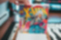 An image of an X Men comic. It has wolverine at the bottom right corner in blue. It has Storm a woman in white as the main character flying forwards.