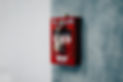 A red fire alarm on a gray wall