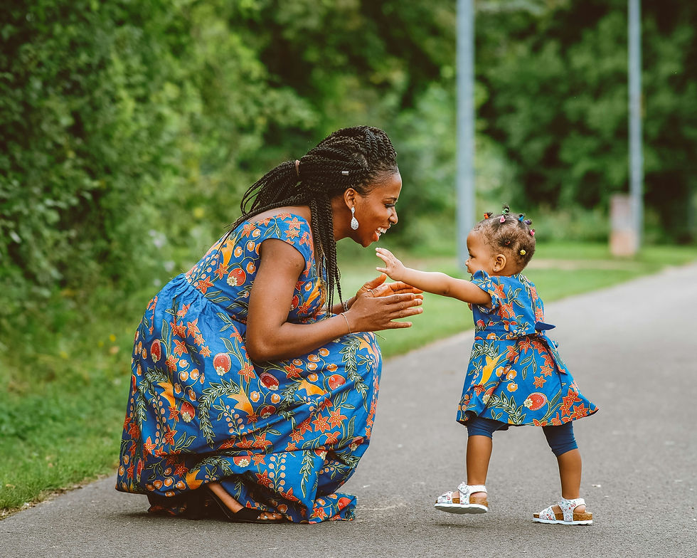 A mother and daughter share a joyful moment on Mother's Day, dressed in matching floral outfits, symbolizing the beautiful bond they share.
