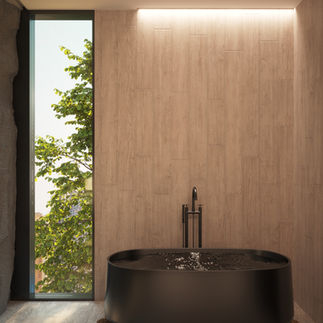 A bold bathtub sits in front of a wooden feature wall sitting next to a tall window for natural light