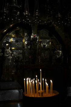 Candles burning in a dark chapel inside the Church of the Holy Sepulchre Jerusalem