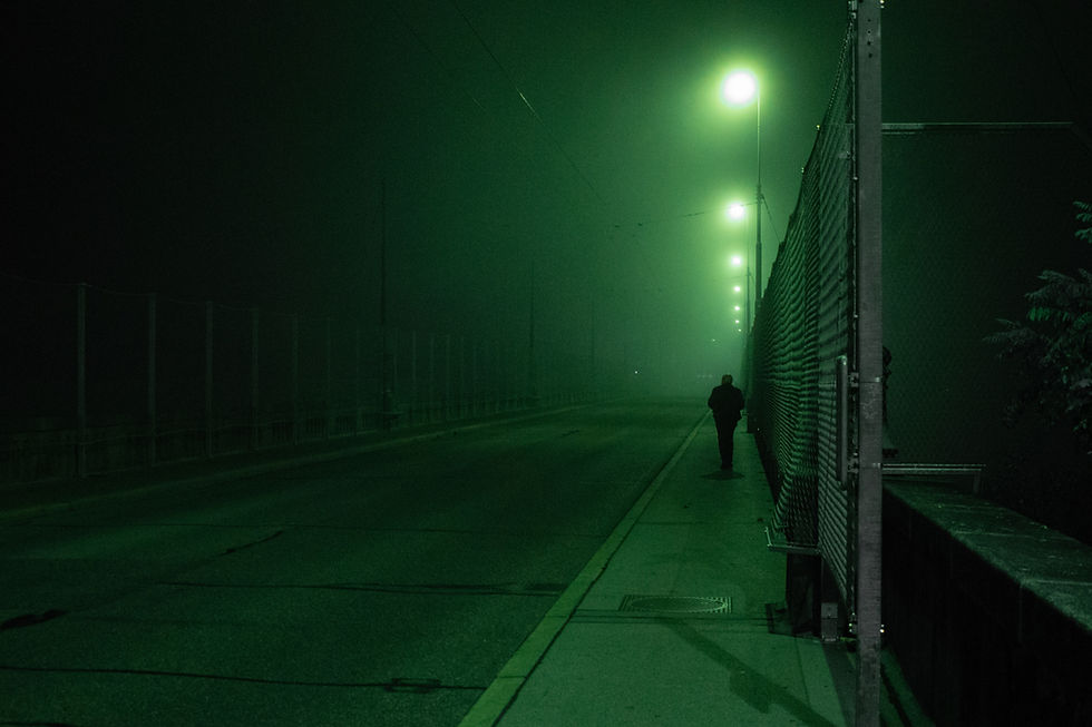 Un homme marche, seul, dans une rue sombre